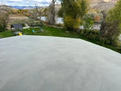 Light gray coated residential deck with protective finish overlooking landscape