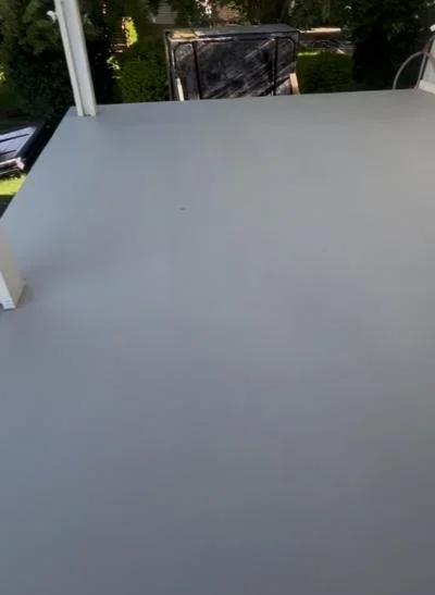 Newly applied gray deck coating on residential deck surface with uniform finish