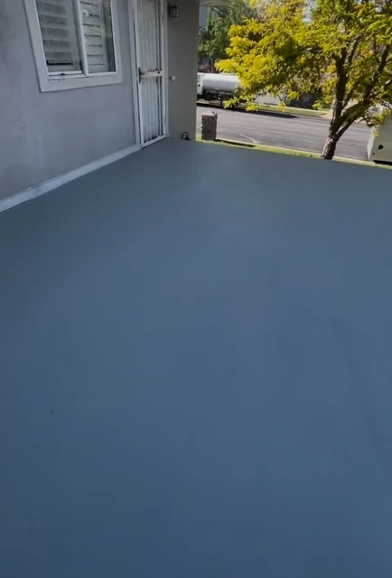 Freshly coated residential deck with slate blue finish and clean edges
