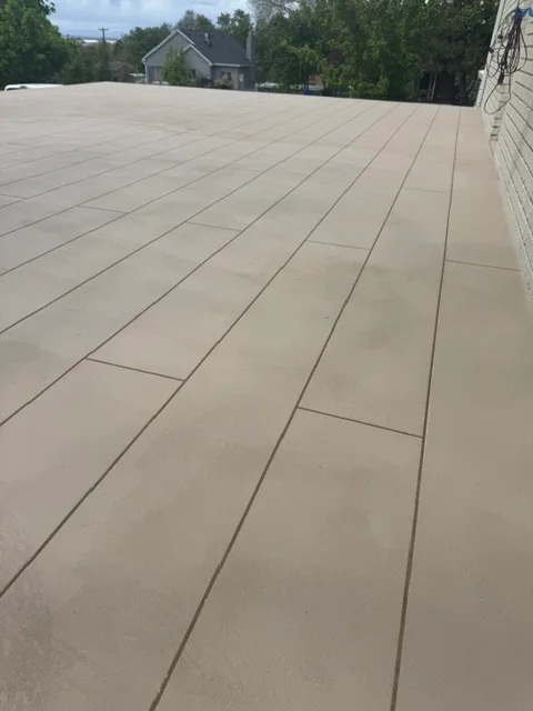 Gray membrane deck coating with uniform seams on flat roof surface