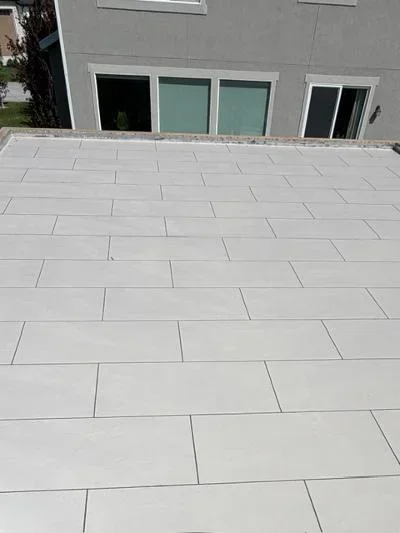 Light gray deck coating in large-format tile pattern on expansive patio surface