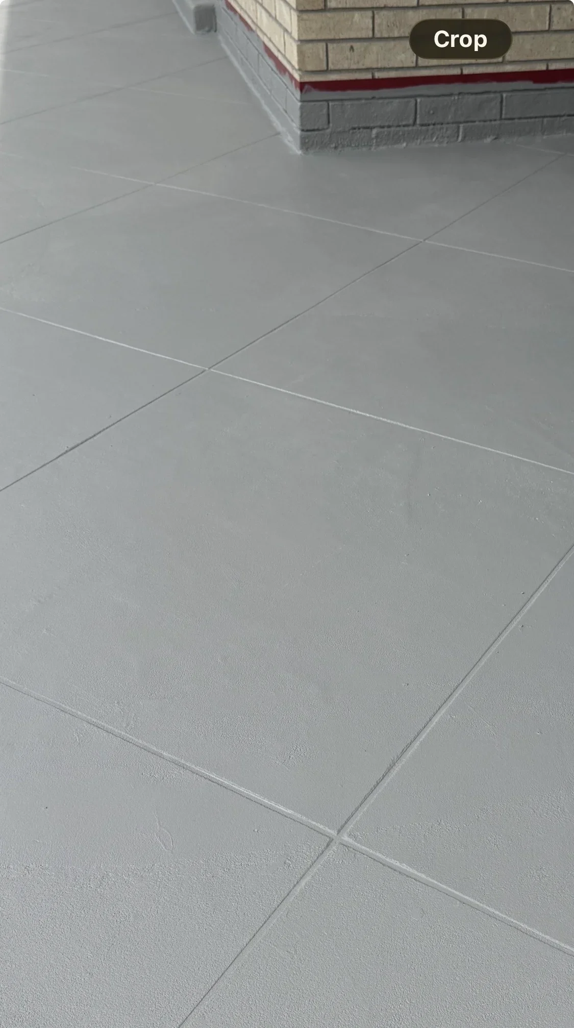 Gray concrete deck coating with clean grout lines and uniform finish on large pavers