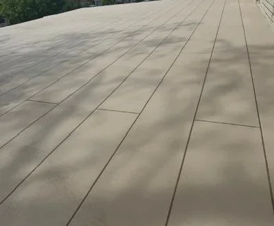 Light gray deck coating on composite boards with clean plank lines and uniform finish