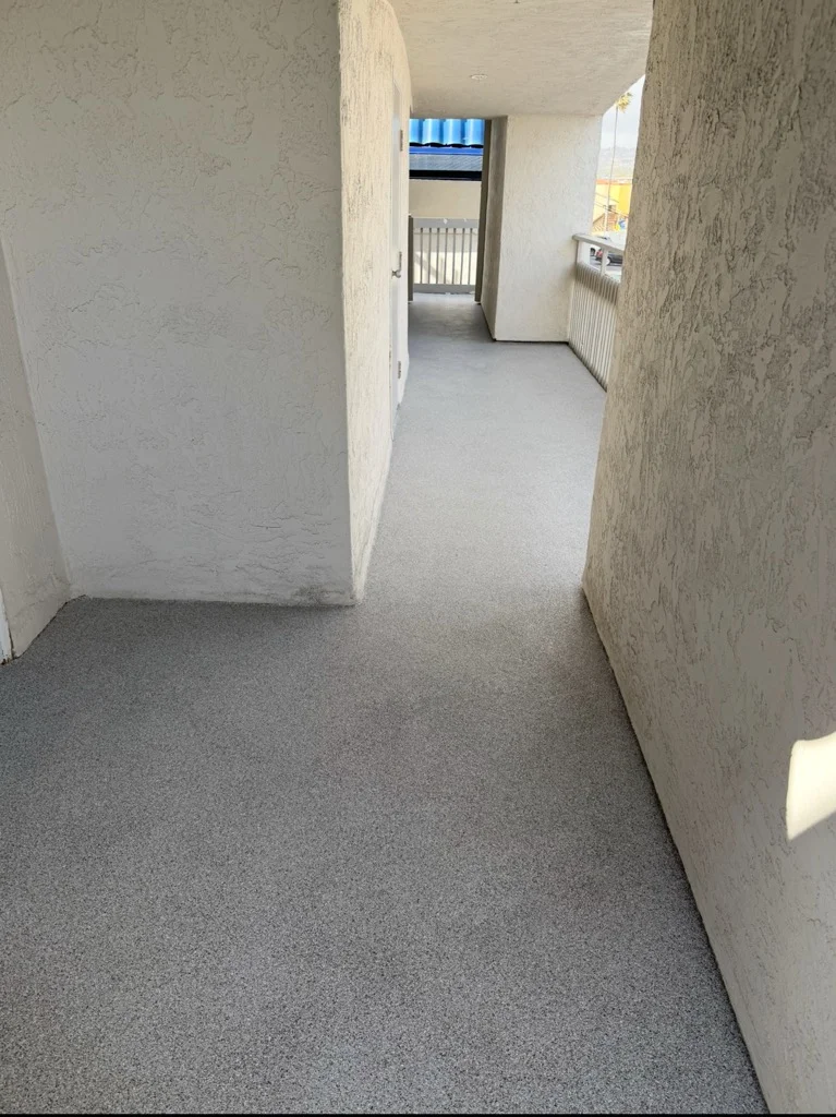 Gray concrete coating flooring in residential hallway with textured walls