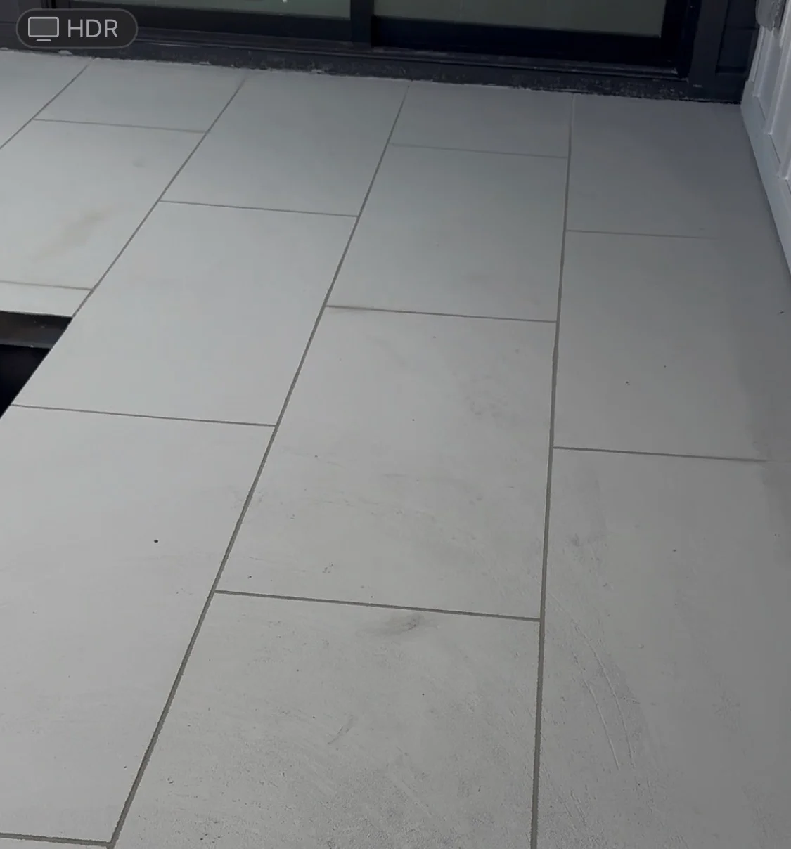 Large format gray porcelain tiles in running bond pattern with gray grout lines