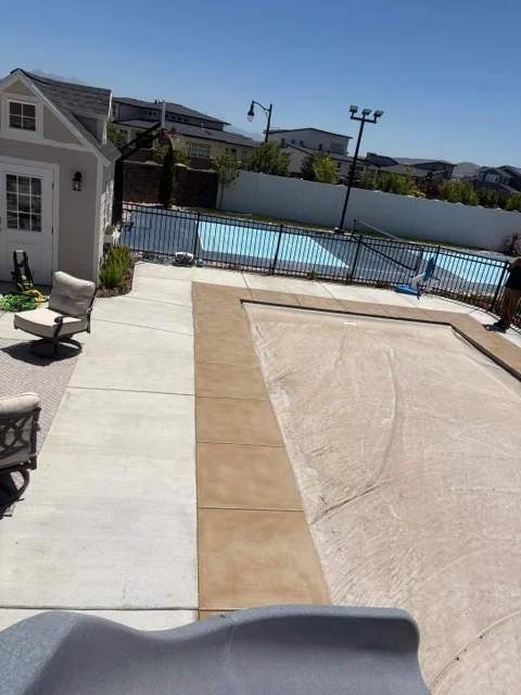 Multi-tone concrete deck coating with light and tan sections around residential pool area