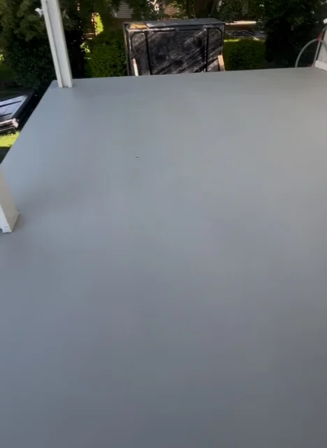 Gray deck coating applied to outdoor deck surface with smooth, even finish