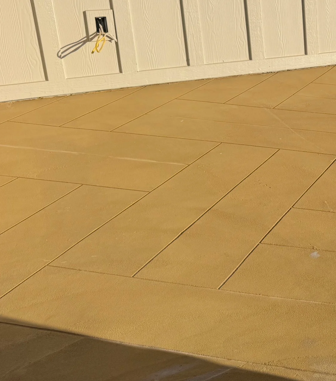 Tan epoxy-coated garage floor with herringbone pattern and clean grout lines