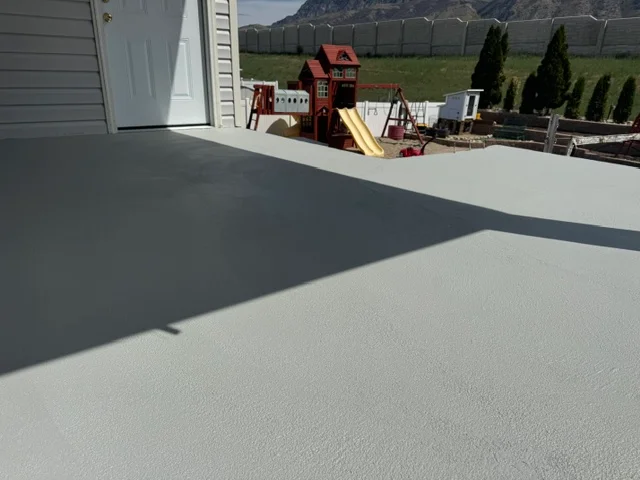 Light gray elastomeric deck coating on residential deck with uniform finish and clean application