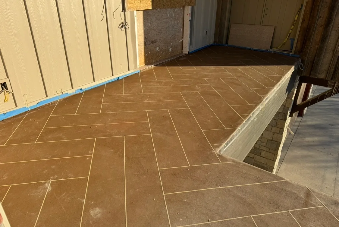 Herringbone patterned brown deck coating with grout lines and protective edge trim