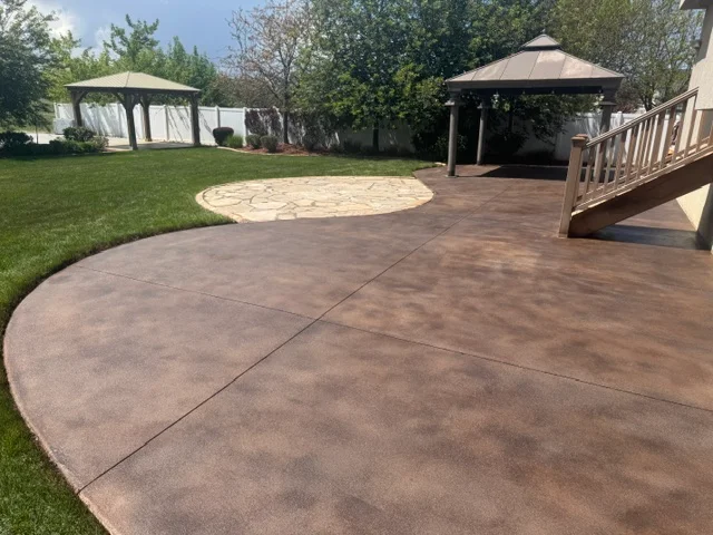 Brown stained concrete patio with circular design accent and control joints
