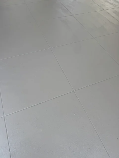 Light gray deck coating with uniform finish and visible grout lines