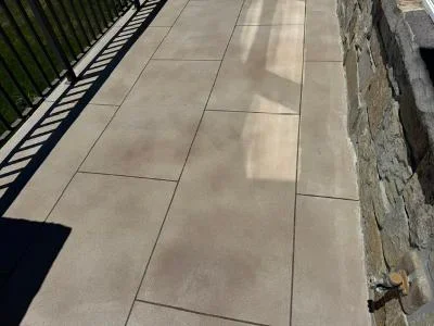 Large concrete deck with neutral coating and large-format paver pattern
